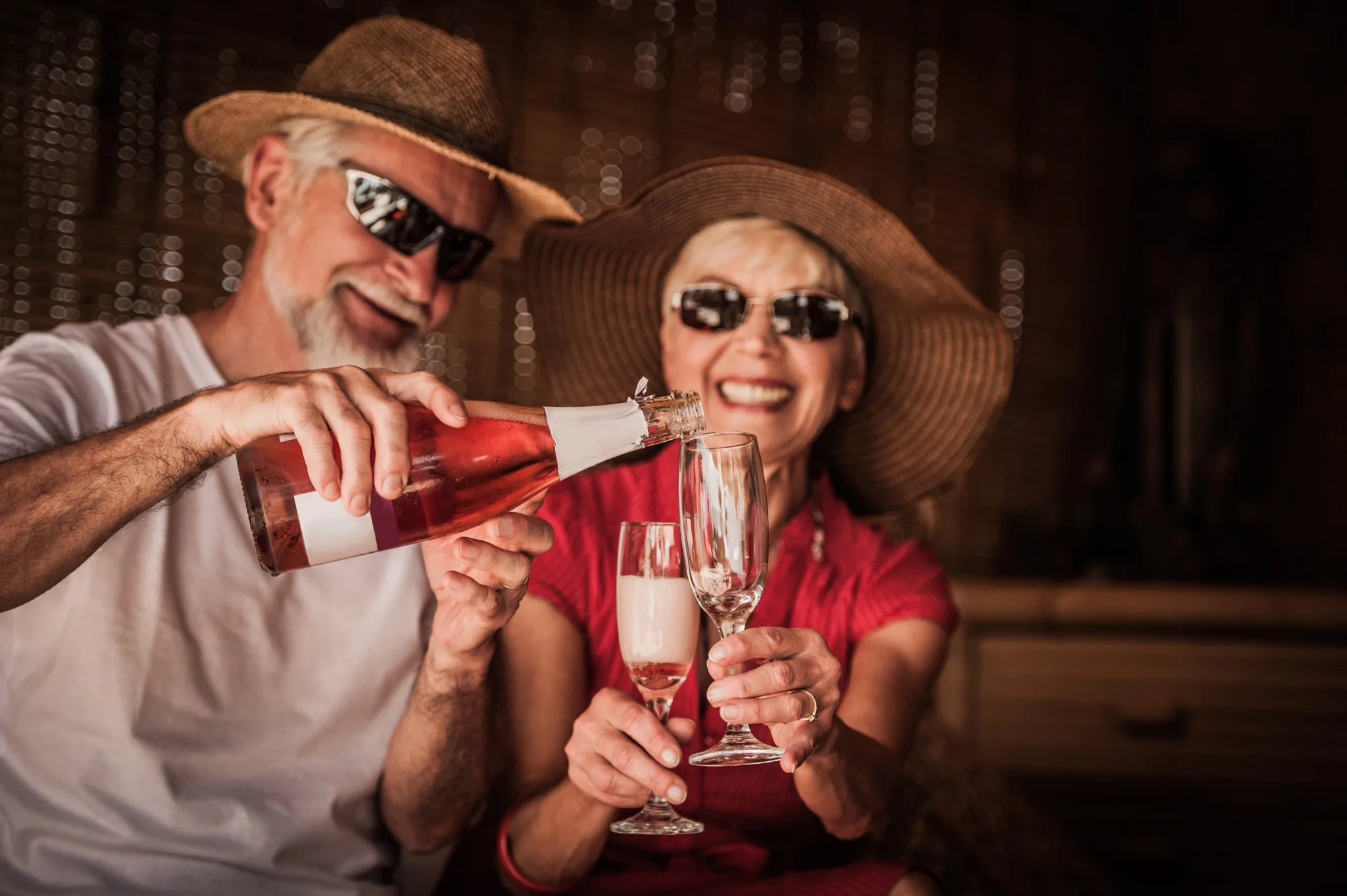 Ein älteres Paar genießt Sekt in einem gemütlichen Ambiente.