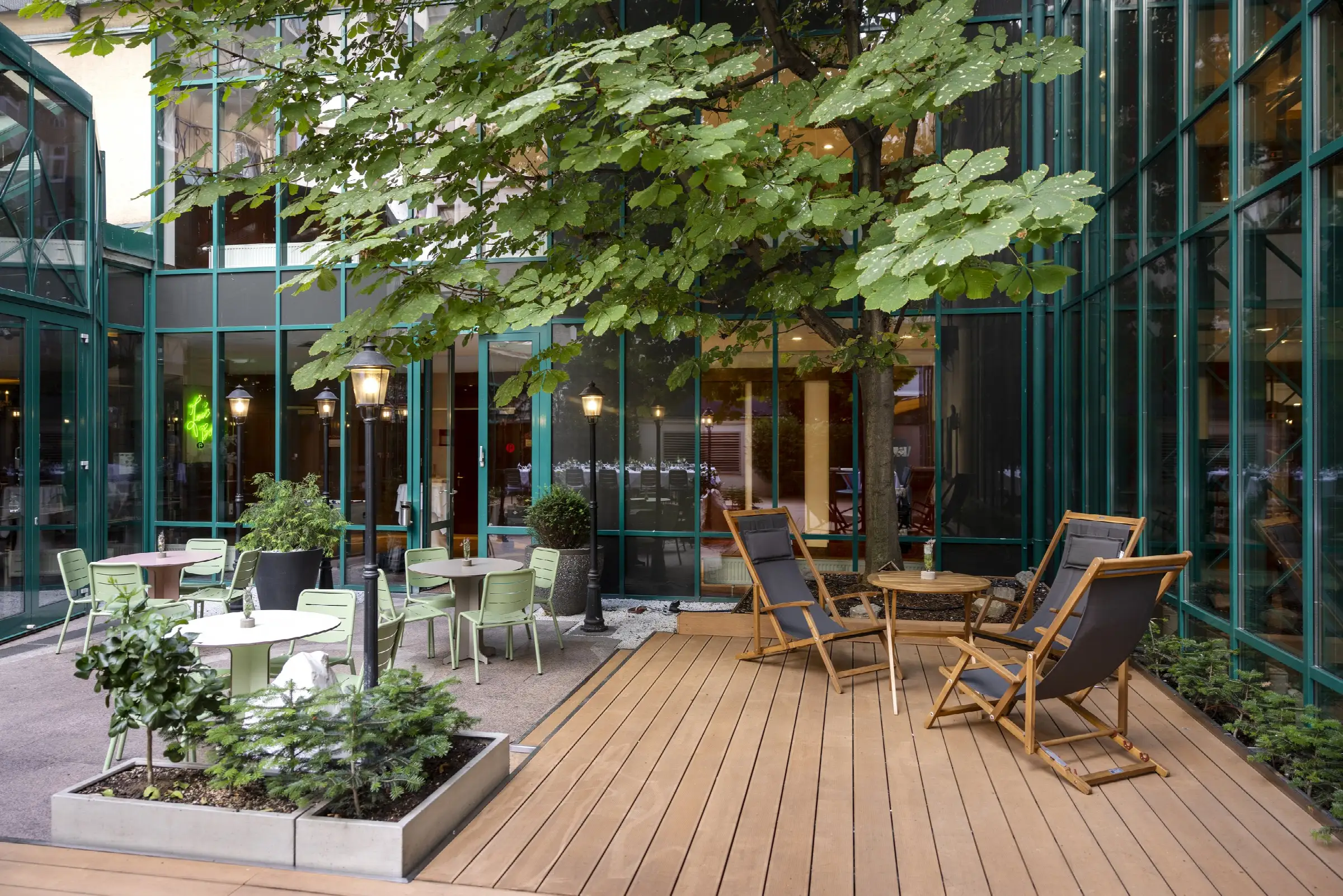 Cozy terrace at the restaurant with modern seating, plants, and a wooden deck.