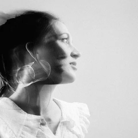 Profile view of a woman with long hair and large earrings.