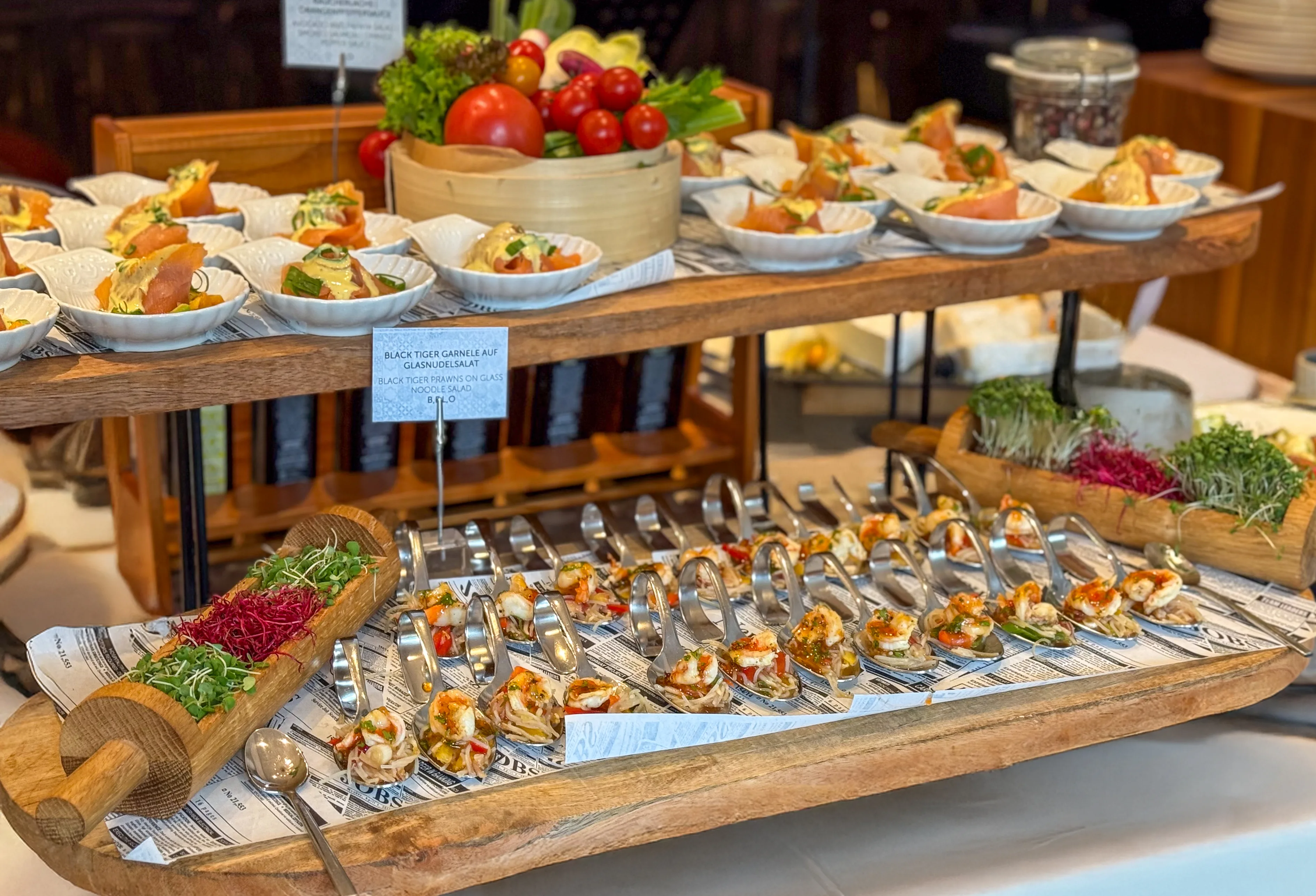 A buffet featuring various shrimp dishes and fresh salad.