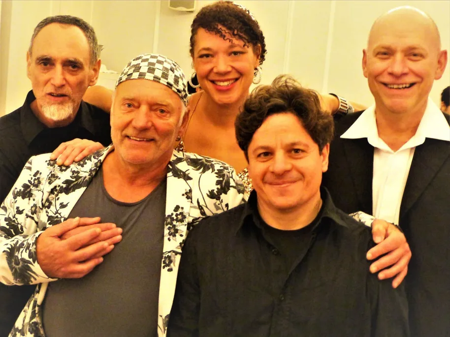 Five people smiling for a photo at a celebration.