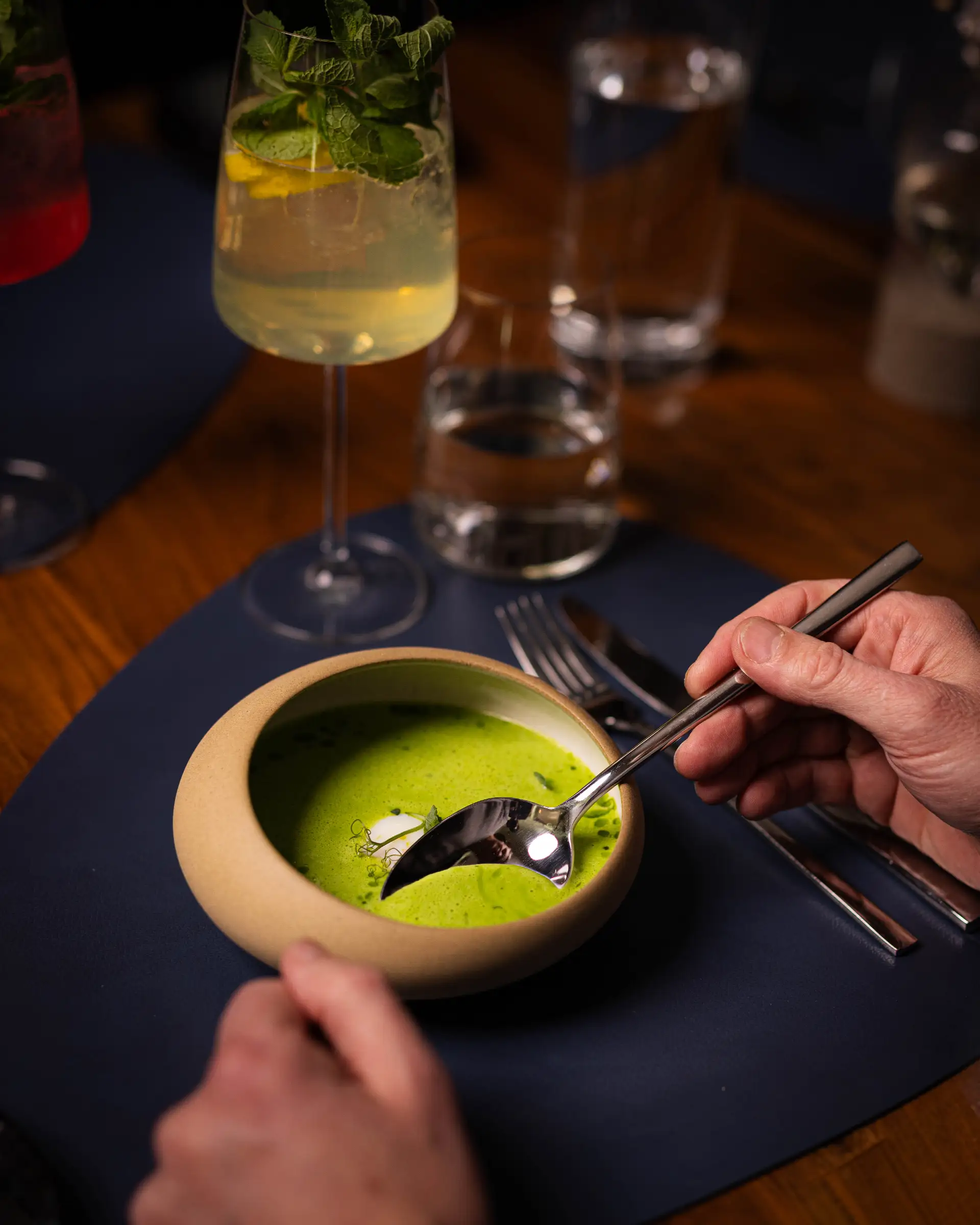 Grüne Suppe mit Kräutern in einem Schälchen, serviert im Restaurant