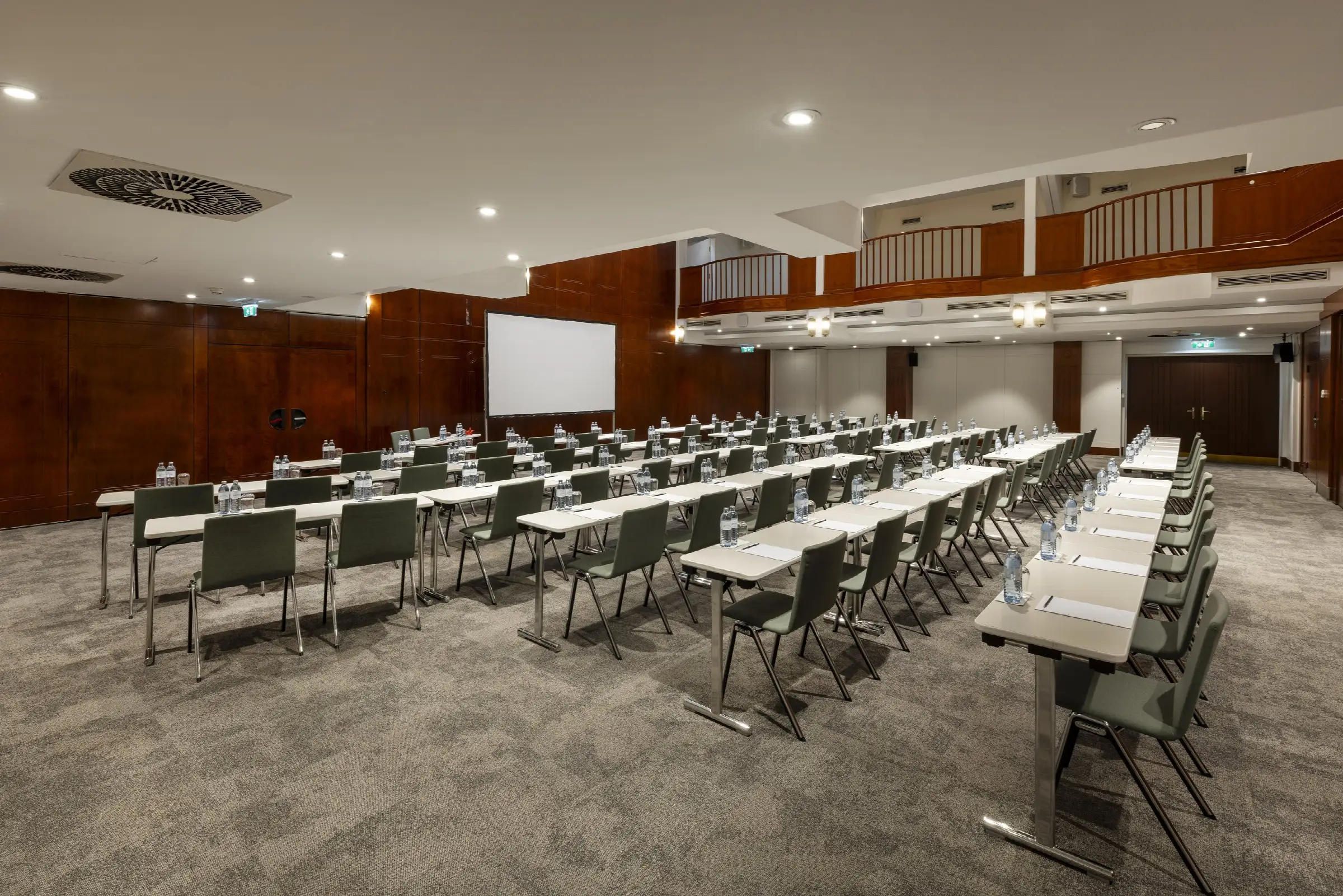 Moderne Tagungsraum im Restaurant mit eleganten Tischen, Stühlen und Wasserflaschen, ideal für Meetings und Veranstaltungen.