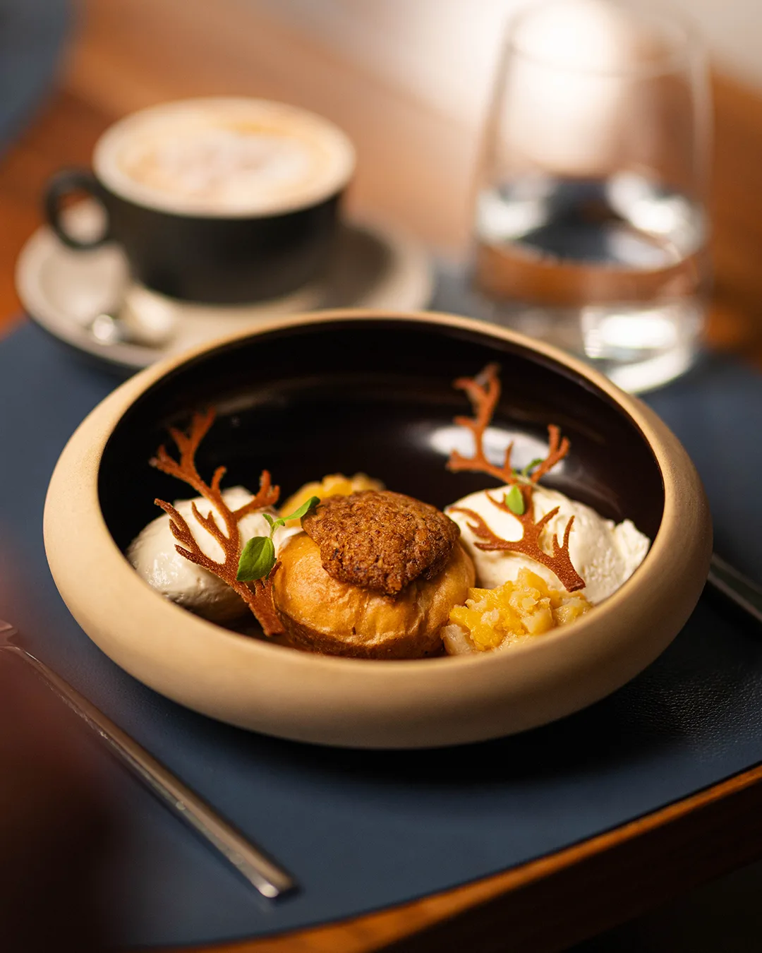 A beautifully arranged dessert with ice cream, pastry, and decoration.