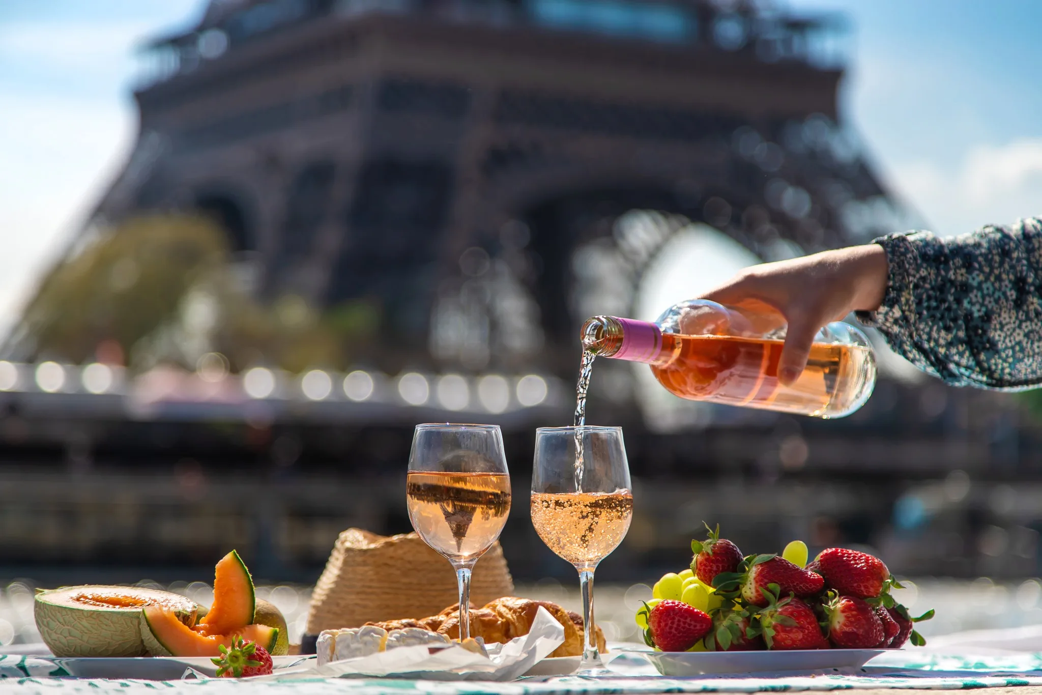 Ein Picknick mit Roséwein, frischen Früchten und einem Blick auf den Eiffelturm.