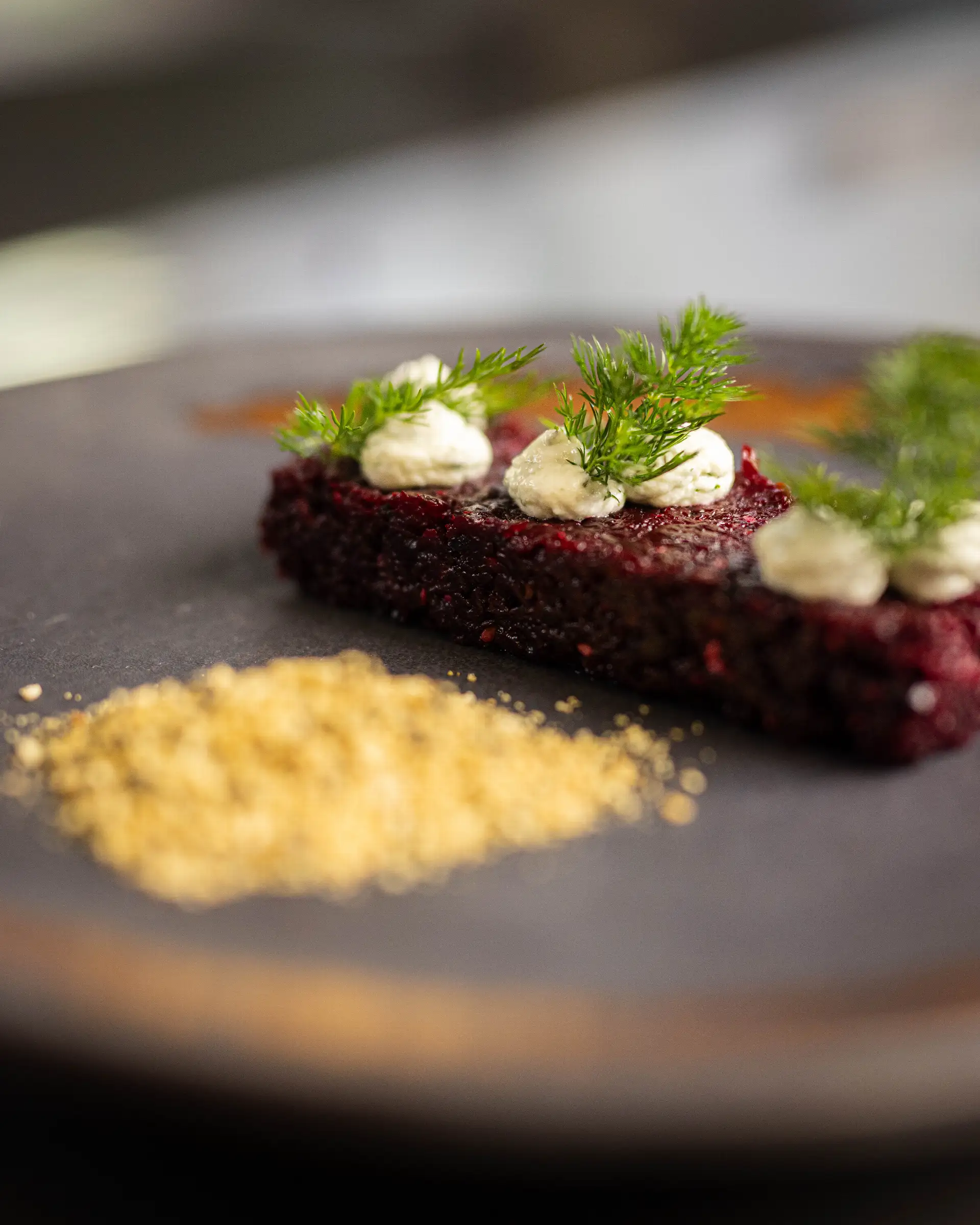 Rote Bete mit Creme und Dill auf schwarzem Teller, serviert im Restaurant.