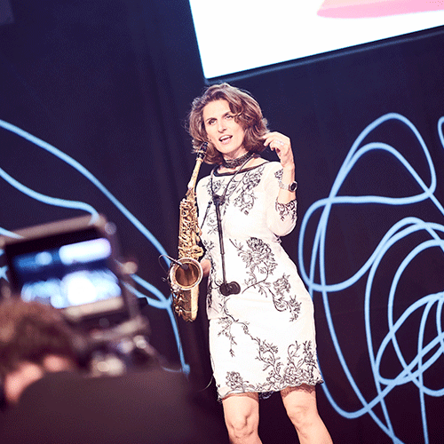 A saxophonist in an elegant dress performing on stage.