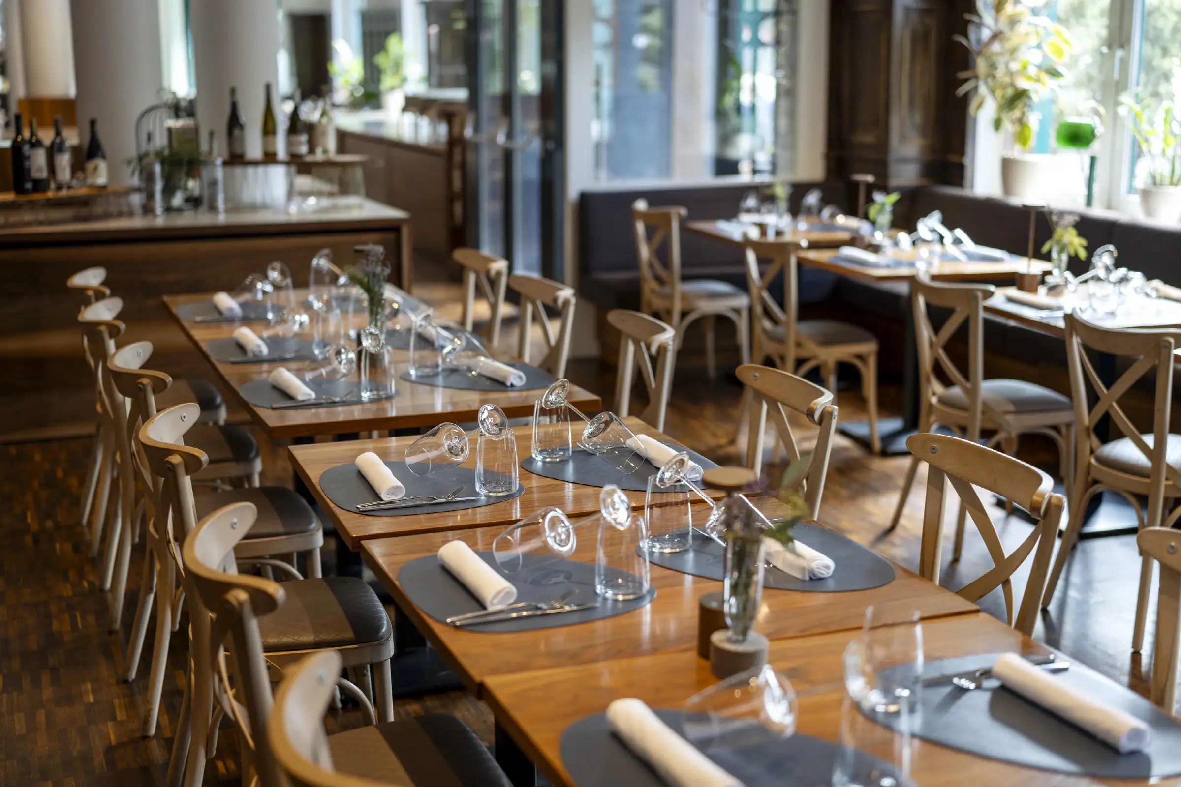 Festlich gedeckter Tisch im Restaurant mit Gläsern, Besteck und Servietten auf eleganten Tischdecken.