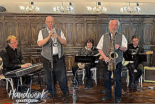 A band performs live music in a restaurant with wooden paneling.